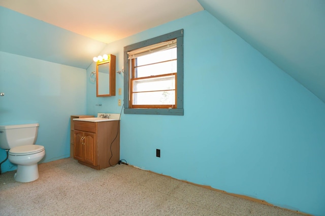 half bath with vaulted ceiling, vanity, and toilet