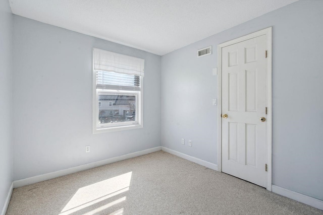 unfurnished room with visible vents, baseboards, and carpet floors