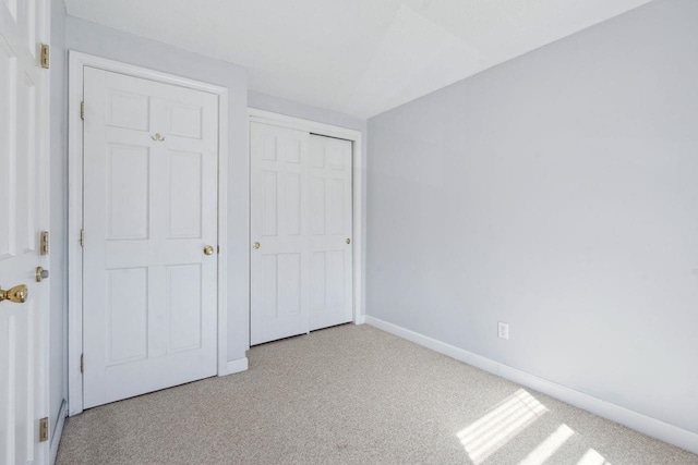 unfurnished bedroom with carpet flooring, baseboards, and a closet