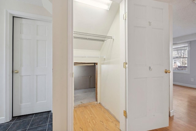 hall with dark wood-style flooring and baseboards