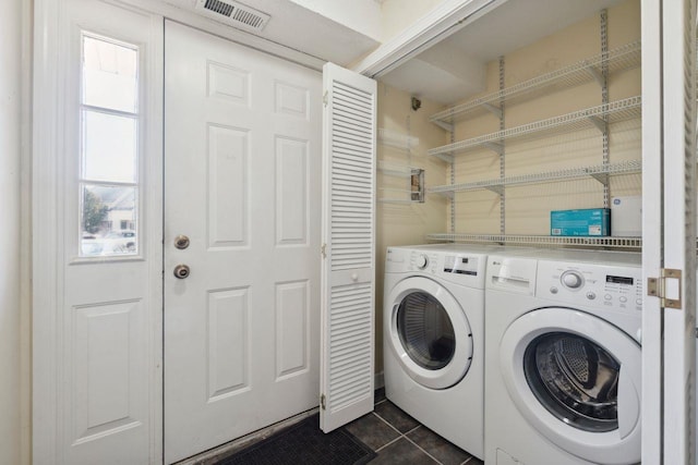 laundry area featuring laundry area, independent washer and dryer, dark tile patterned flooring, and visible vents