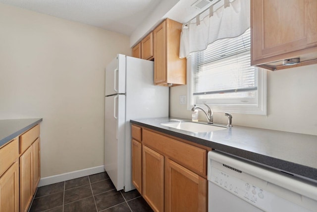 kitchen with a sink, dark tile patterned floors, visible vents, white dishwasher, and dark countertops