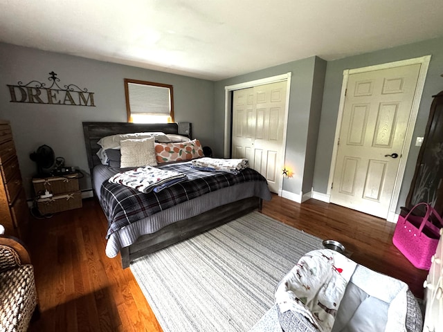 bedroom with a closet, wood finished floors, and baseboards