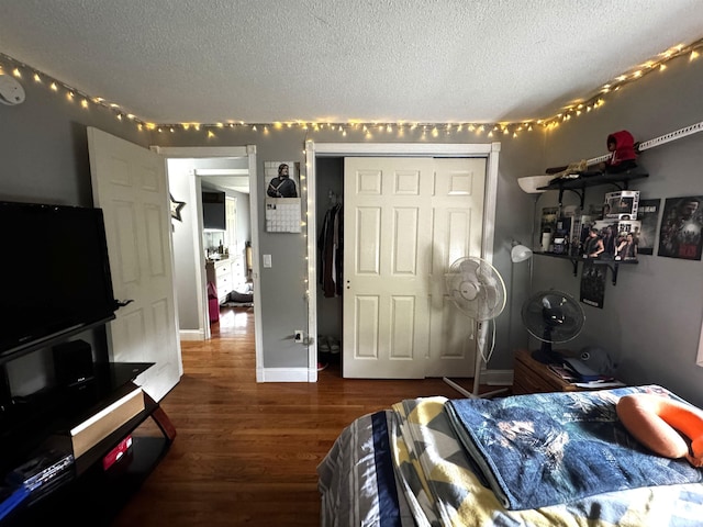 bedroom with a textured ceiling and wood finished floors