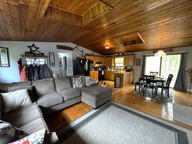 living room with lofted ceiling, light wood finished floors, attic access, and wood ceiling