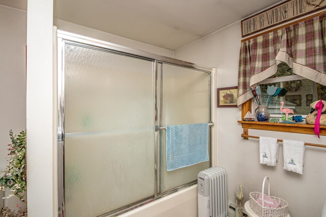 full bath with enclosed tub / shower combo, toilet, and radiator heating unit