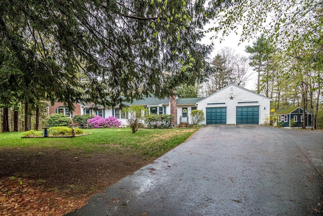 ranch-style home with a garage, a front yard, and aphalt driveway