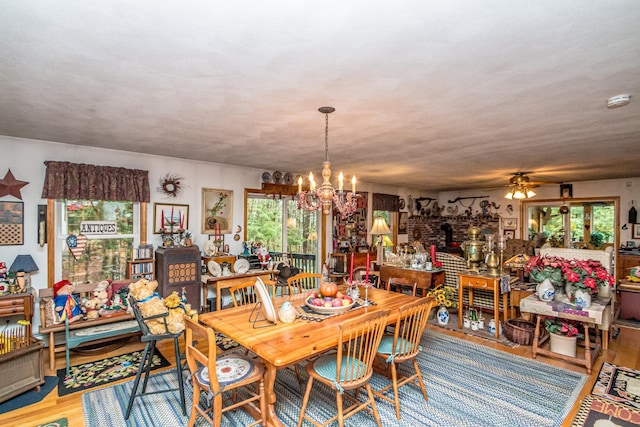 dining room featuring ceiling fan with notable chandelier and light wood-type flooring