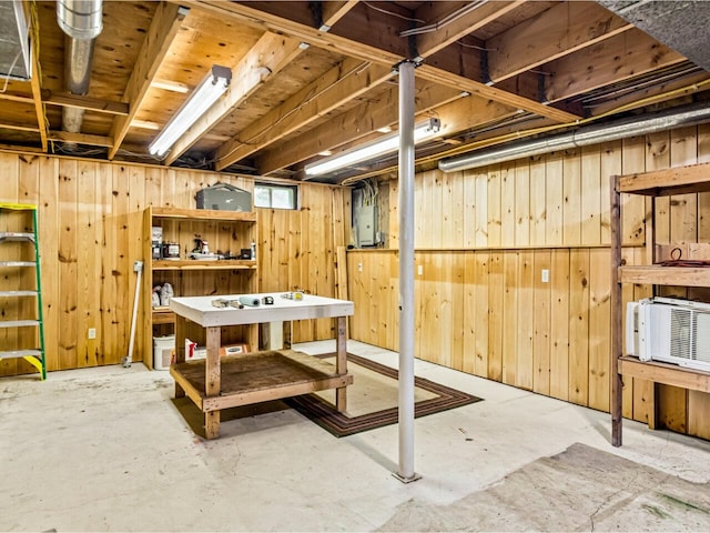 basement with electric panel and wooden walls