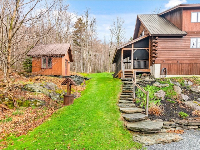 view of yard featuring stairs, an outbuilding, and a sunroom