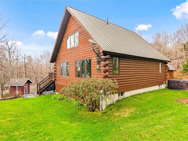 view of home's exterior with log siding, metal roof, and a yard