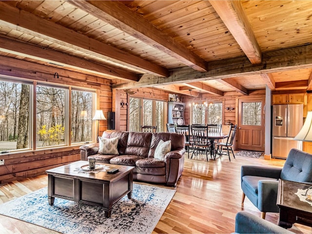 living area with wooden walls, wood ceiling, light wood-style flooring, and plenty of natural light