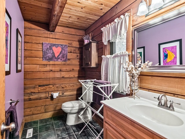 bathroom with wood ceiling, toilet, beam ceiling, wooden walls, and vanity