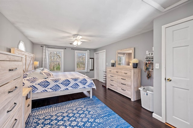 bedroom featuring baseboards, a ceiling fan, a closet, and dark wood finished floors