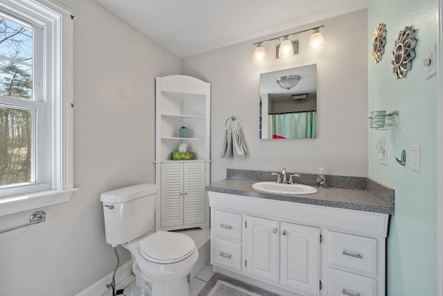bathroom with vanity, toilet, baseboards, and tile patterned floors