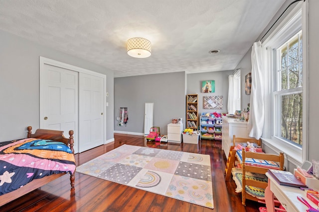 bedroom featuring baseboards, multiple windows, and wood finished floors
