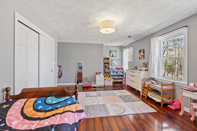 bedroom featuring a closet, a textured ceiling, and wood finished floors