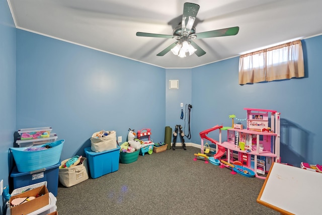 rec room with crown molding, carpet flooring, baseboards, and a ceiling fan
