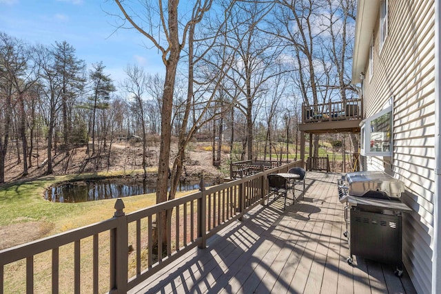 wooden deck featuring a lawn and a water view