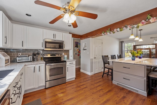 kitchen featuring backsplash, stainless steel appliances, and white cabinets