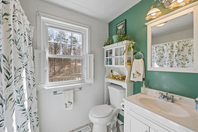 full bathroom with toilet, baseboards, vanity, and visible vents