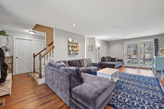 living area with recessed lighting, visible vents, wood finished floors, and stairs