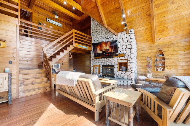 93 Roller Coaster Rd, Laconia, NH 03246 - living room featuring a stone fireplace, wood finished floors, wood ceiling, wood walls, and stairway