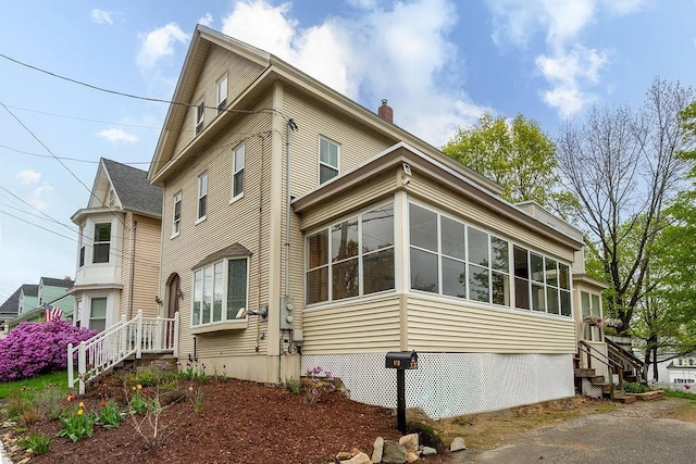 172 High St, Somersworth, NH 03878 - view of home's exterior with a sunroom and a chimney
