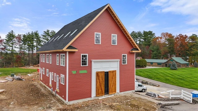 view of side of home featuring a shingled roof and a detached garage