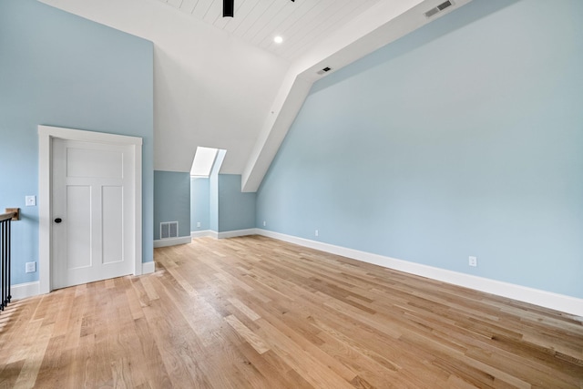 bonus room featuring lofted ceiling, light wood finished floors, and baseboards