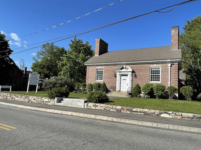 60 Effingham Rd, Ossipee, NH 03864 - view of front of house featuring a front yard, a chimney, and brick siding