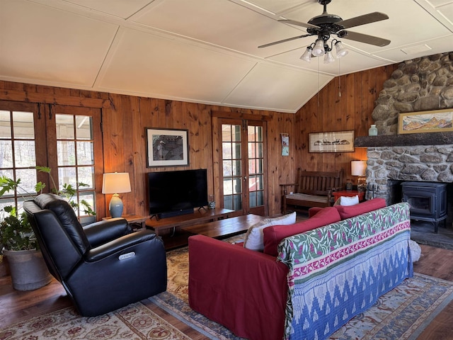 60 Effingham Rd, Ossipee, NH 03864 - living room with wooden walls, wood finished floors, a ceiling fan, a wood stove, and french doors