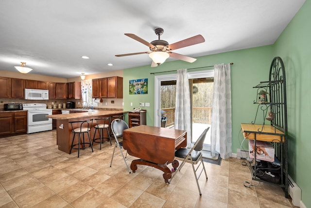 dining area with recessed lighting, a ceiling fan, a baseboard radiator, and baseboards