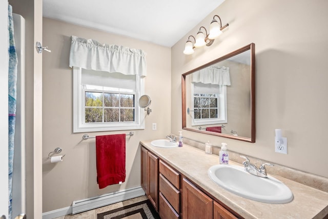 bathroom featuring a baseboard radiator, double vanity, and baseboards