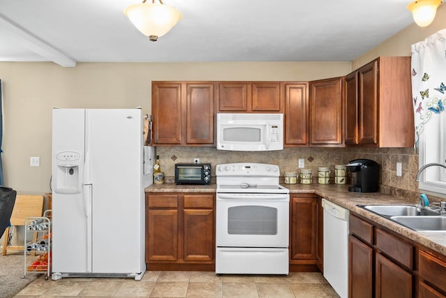 kitchen featuring white appliances, a sink, tasteful backsplash, and brown cabinets