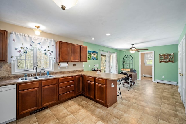 kitchen featuring a sink, white dishwasher, a peninsula, baseboard heating, and recessed lighting