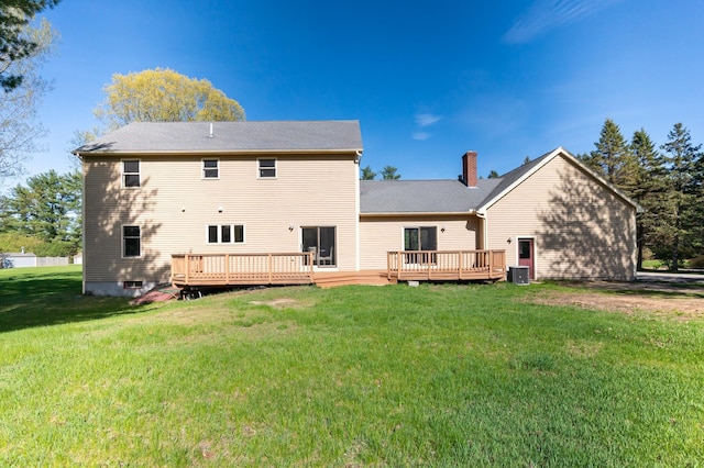 rear view of property with a wooden deck and a lawn
