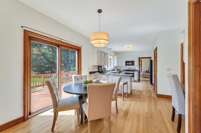 dining room featuring light wood-style flooring and baseboards
