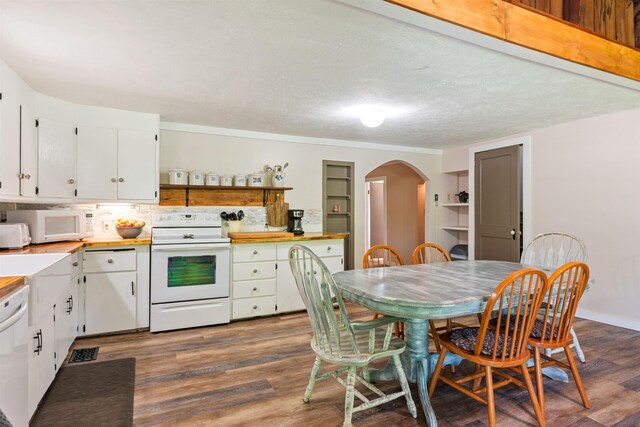kitchen featuring white appliances, arched walkways, dark wood finished floors, white cabinets, and open shelves