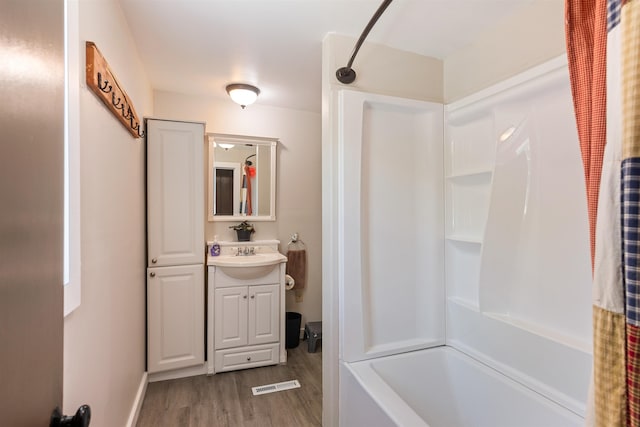 full bath with wood finished floors, vanity, and shower / bath combo