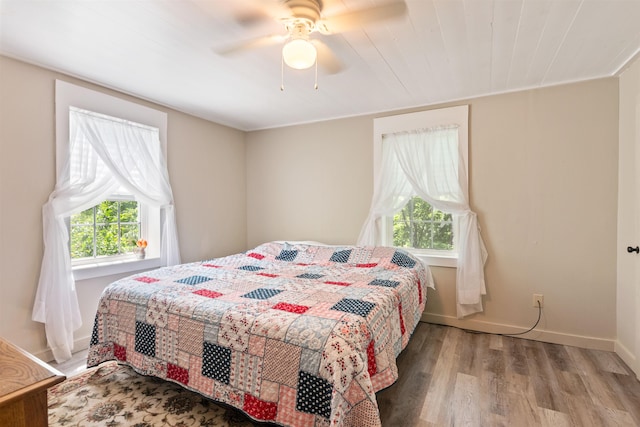bedroom featuring wood finished floors, ceiling fan, and baseboards