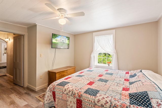 bedroom featuring light wood finished floors, ceiling fan, and baseboards