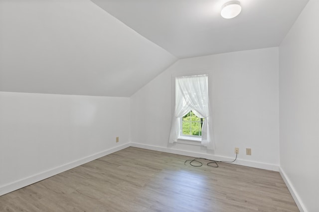 bonus room with vaulted ceiling, wood finished floors, and baseboards