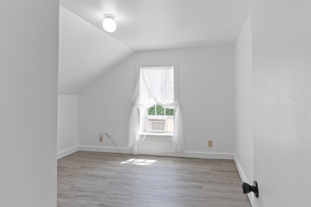 bonus room featuring wood finished floors, lofted ceiling, cooling unit, and baseboards