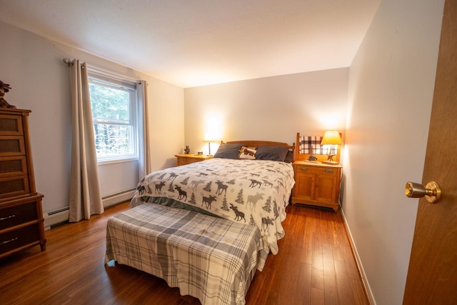 bedroom featuring wood finished floors, baseboards, and baseboard heating
