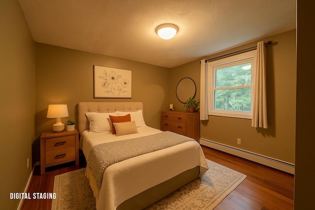 bedroom featuring baseboard heating, wood finished floors, and baseboards