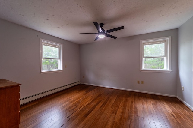 spare room with a baseboard heating unit, hardwood / wood-style floors, baseboards, and a ceiling fan