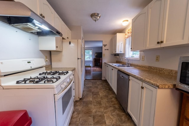 kitchen featuring stainless steel appliances, a sink, range hood, and healthy amount of natural light