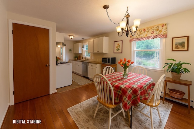 dining room featuring a chandelier, wood finished floors, and baseboards