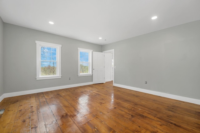 unfurnished room with baseboards, wood-type flooring, and recessed lighting